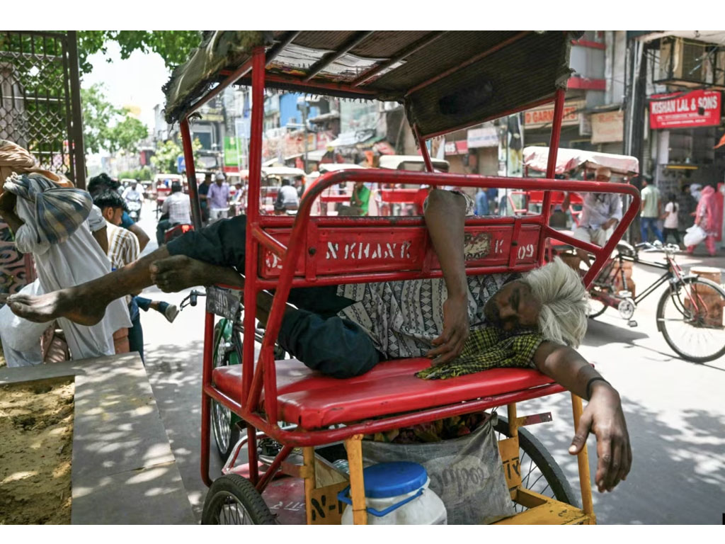 pria tertidur di atas rickshaw di India
